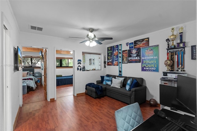 living room with hardwood / wood-style flooring, crown molding, and ceiling fan