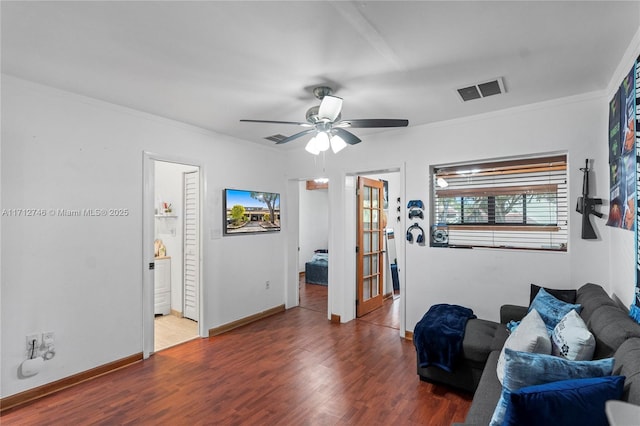 living room with hardwood / wood-style flooring, ceiling fan, and ornamental molding