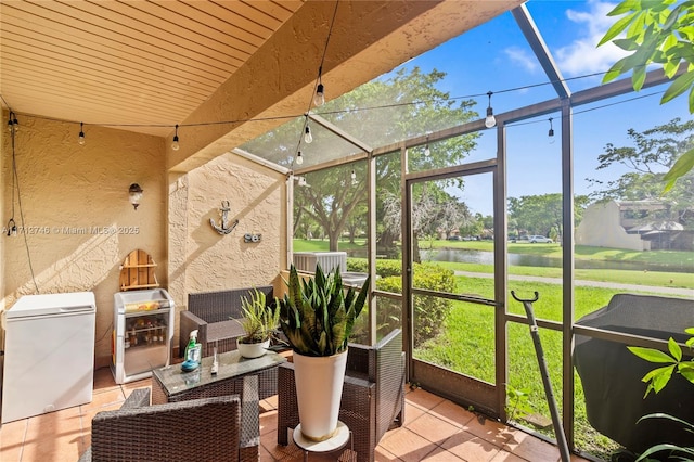 sunroom / solarium featuring heating unit and a water view