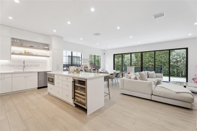 kitchen featuring beverage cooler, visible vents, dishwasher, open shelves, and a sink