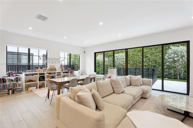 living area with wood finished floors, visible vents, and recessed lighting