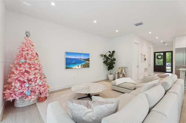 living area with recessed lighting, visible vents, and baseboards