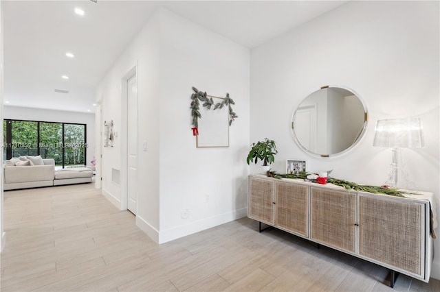 hallway featuring recessed lighting, baseboards, and wood finished floors