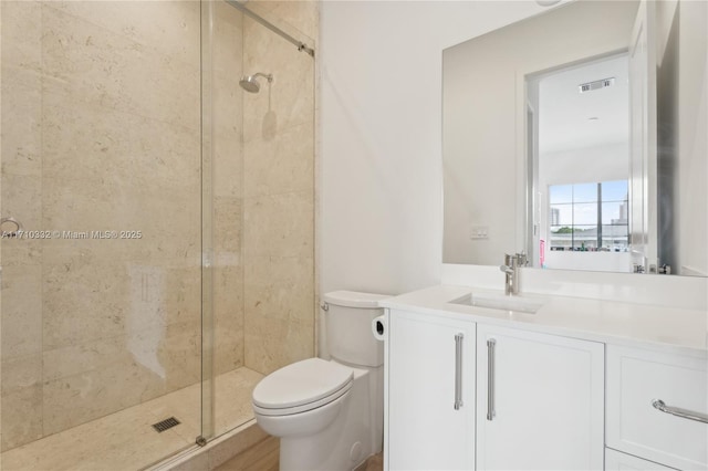 bathroom with visible vents, a stall shower, vanity, and toilet