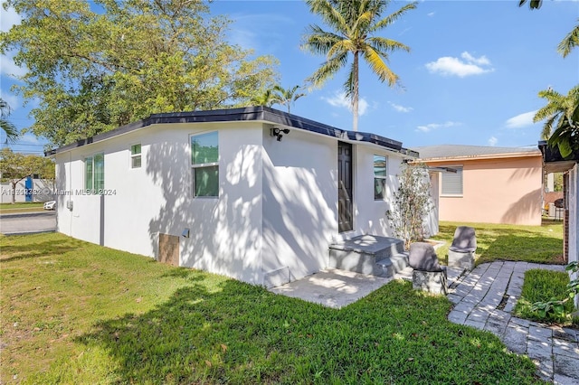 rear view of house featuring a yard and a patio