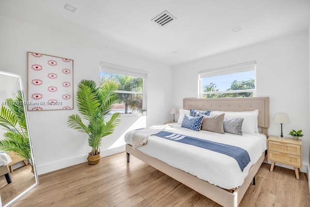 bedroom with light hardwood / wood-style flooring and multiple windows