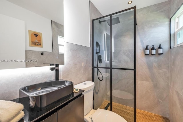 bathroom featuring an enclosed shower, vanity, toilet, and tile walls