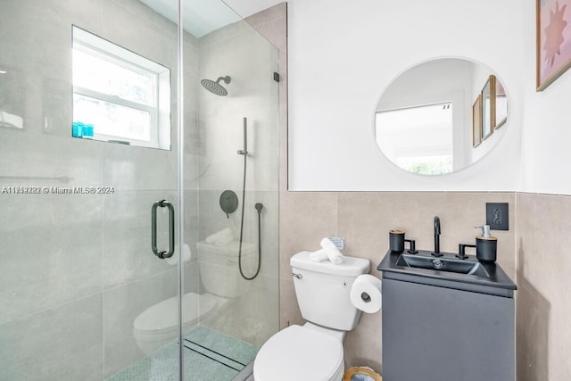 bathroom featuring vanity, toilet, an enclosed shower, and tile walls