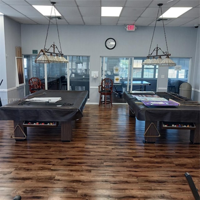 game room with dark wood-type flooring, pool table, a drop ceiling, and a towering ceiling