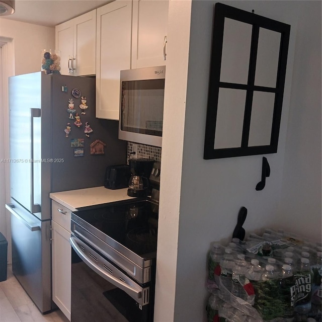 kitchen with light countertops, white cabinets, and appliances with stainless steel finishes