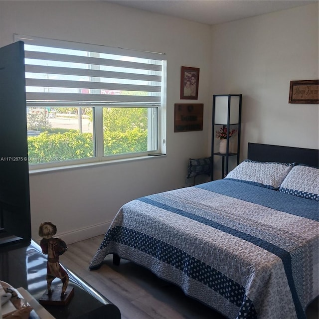 bedroom featuring baseboards and wood finished floors