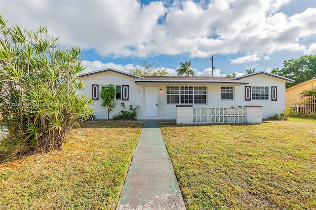 single story home featuring a front lawn