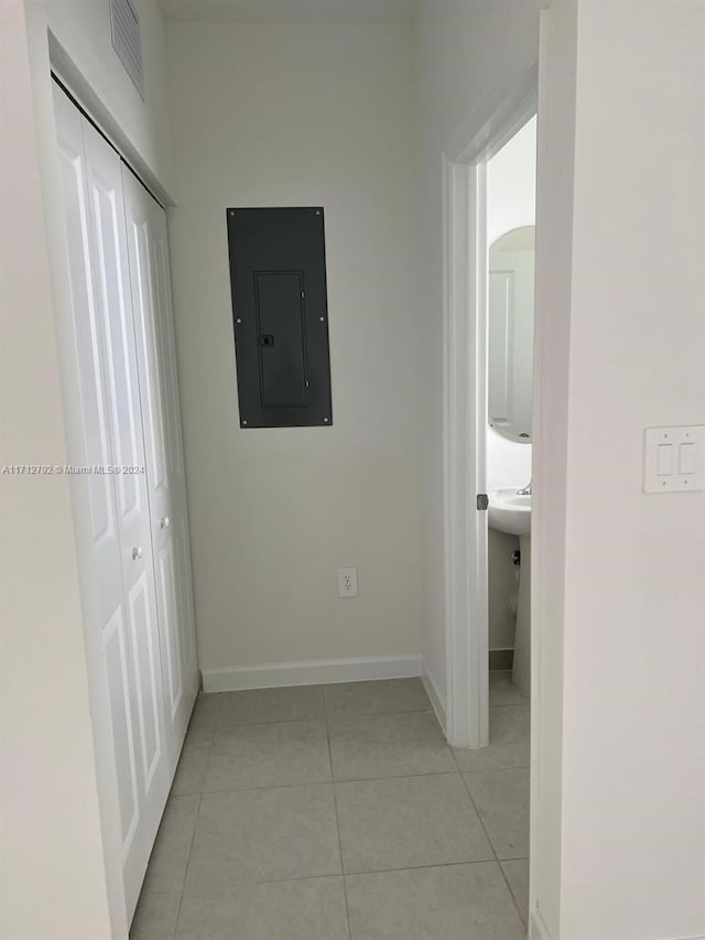 corridor featuring light tile patterned floors and electric panel