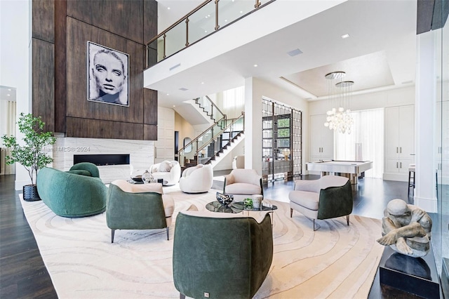 living room featuring a fireplace, wood-type flooring, and a tray ceiling