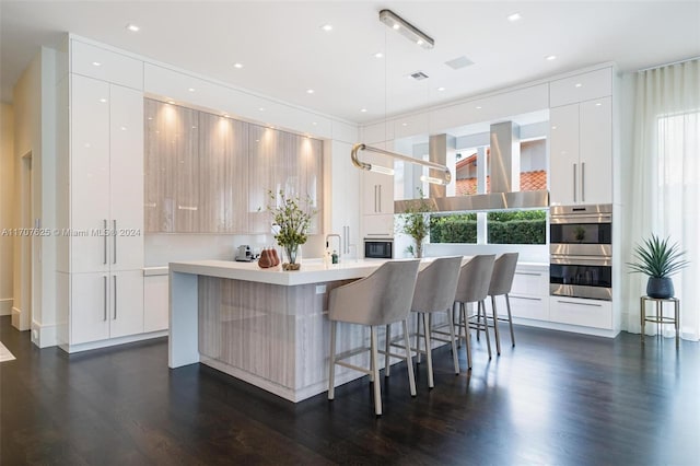 kitchen with decorative light fixtures, white cabinets, and a kitchen island