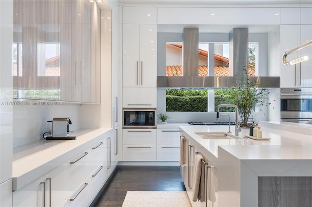 kitchen featuring oven, a wealth of natural light, sink, black microwave, and white cabinets