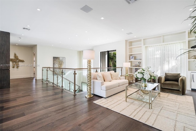 living room with dark wood-type flooring and built in features