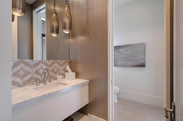 bathroom with toilet, vanity, tile patterned floors, and tasteful backsplash