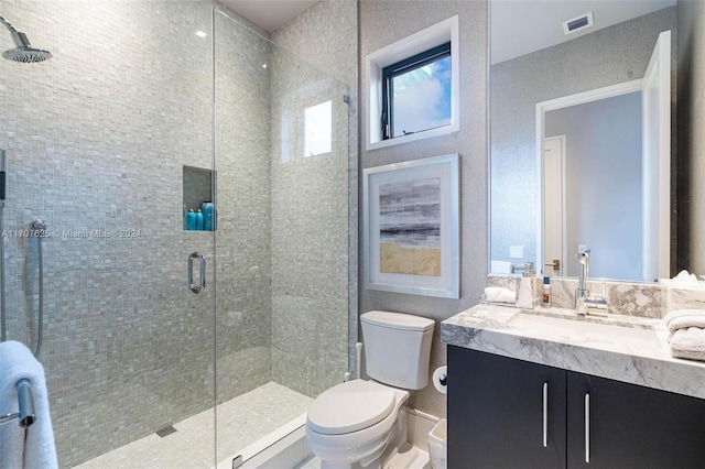 bathroom with toilet, vanity, and walk in shower