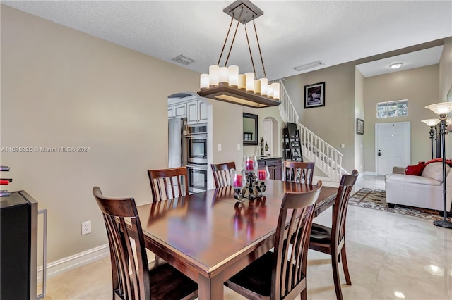 tiled dining space with a textured ceiling