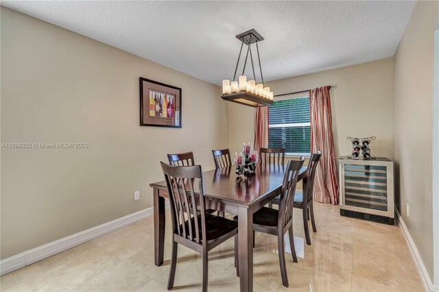 dining space featuring wine cooler and a textured ceiling