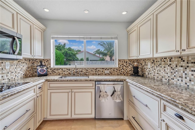 kitchen with cream cabinetry, decorative backsplash, sink, and appliances with stainless steel finishes