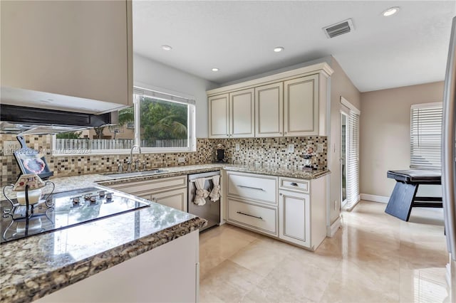 kitchen featuring decorative backsplash, stainless steel dishwasher, black electric cooktop, sink, and cream cabinets