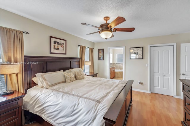 bedroom featuring light wood-type flooring, a textured ceiling, ceiling fan, connected bathroom, and a closet