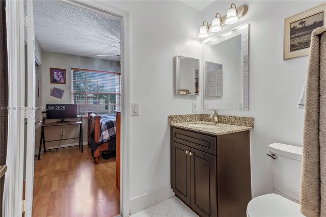 bathroom featuring vanity, toilet, and a textured ceiling