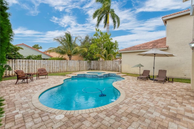 view of swimming pool featuring a patio area and an in ground hot tub