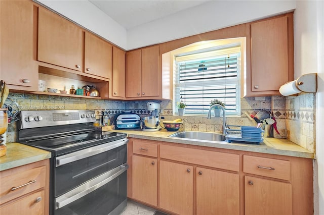 kitchen featuring electric range, backsplash, light tile patterned flooring, and sink