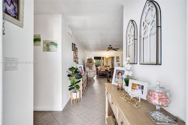 hallway featuring light tile patterned floors and a textured ceiling