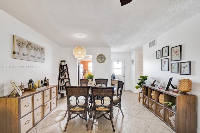 dining area featuring light tile patterned floors and a textured ceiling