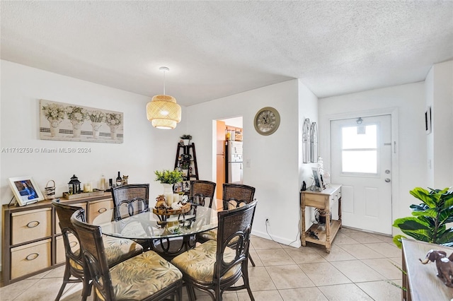 tiled dining room featuring a textured ceiling