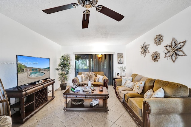 living room featuring ceiling fan, light tile patterned flooring, and a textured ceiling