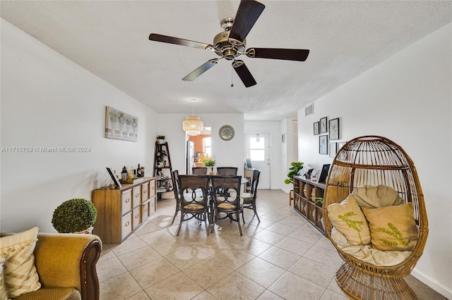 dining room with ceiling fan, light tile patterned flooring, and a textured ceiling