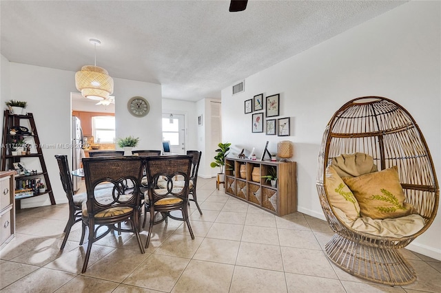 tiled dining area featuring a textured ceiling