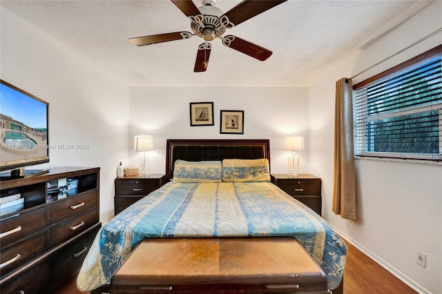 bedroom with wood-type flooring, a textured ceiling, and ceiling fan