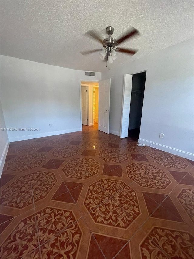 interior space featuring ceiling fan and a textured ceiling