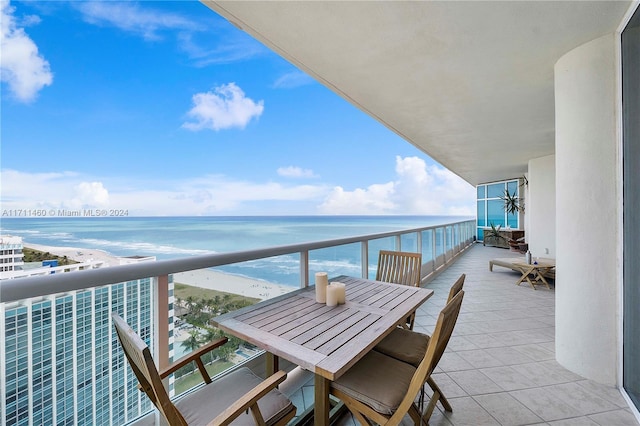 balcony featuring a water view and a view of the beach