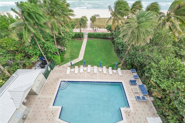 view of pool featuring a lawn and a water view