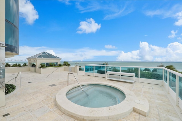 view of pool featuring an in ground hot tub and a water view