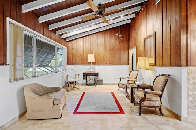 living area featuring lofted ceiling with beams, ceiling fan, and wood walls