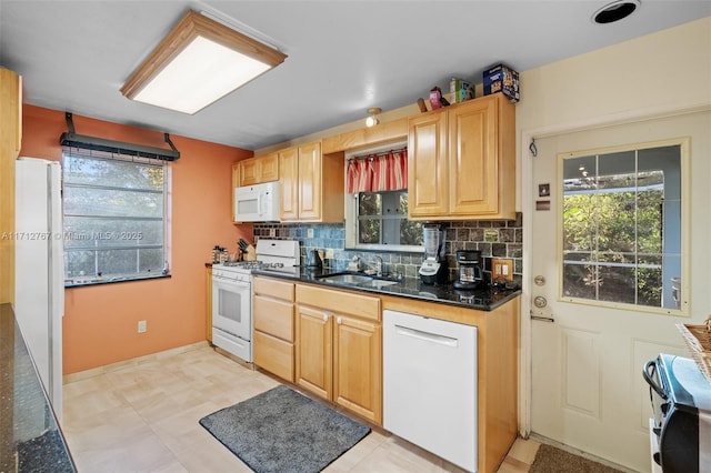 kitchen with tasteful backsplash, sink, white appliances, and dark stone counters