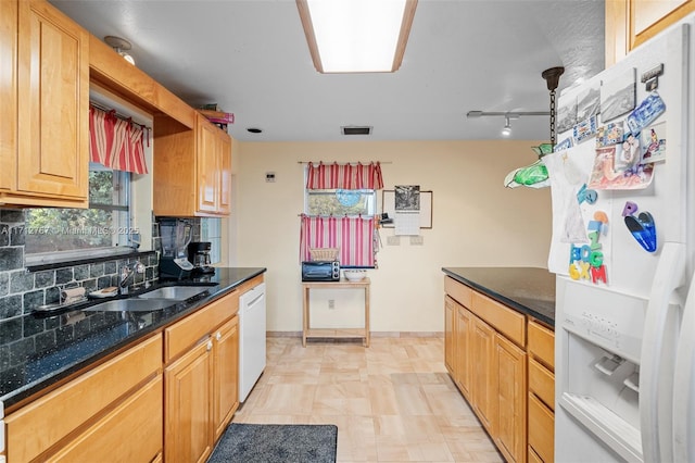 kitchen featuring sink, backsplash, and white appliances