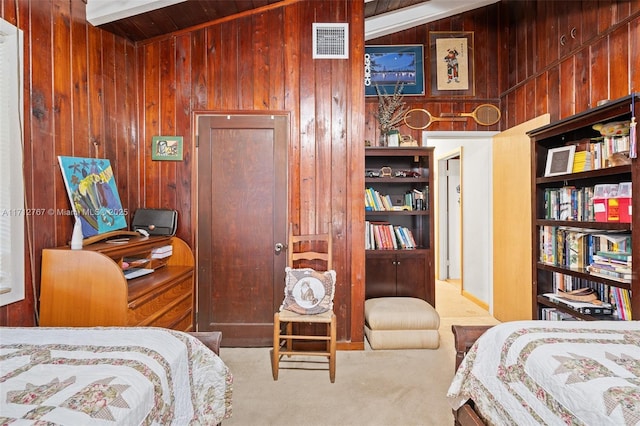 carpeted bedroom with wood walls