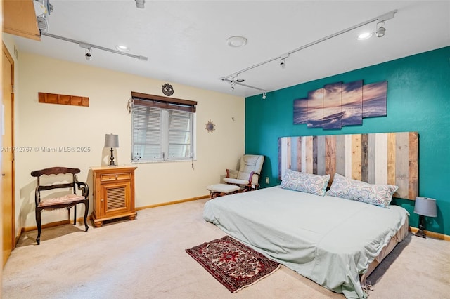 carpeted bedroom featuring rail lighting