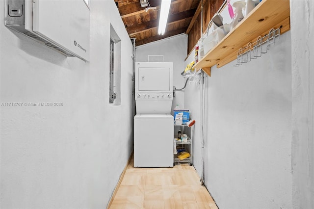 washroom featuring stacked washer and clothes dryer and wooden ceiling