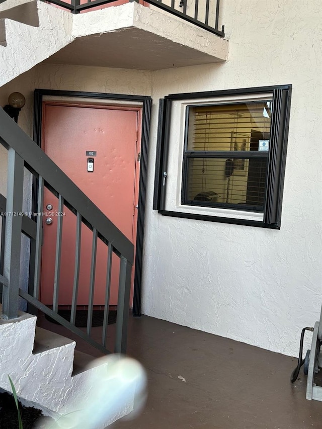 view of exterior entry with a balcony