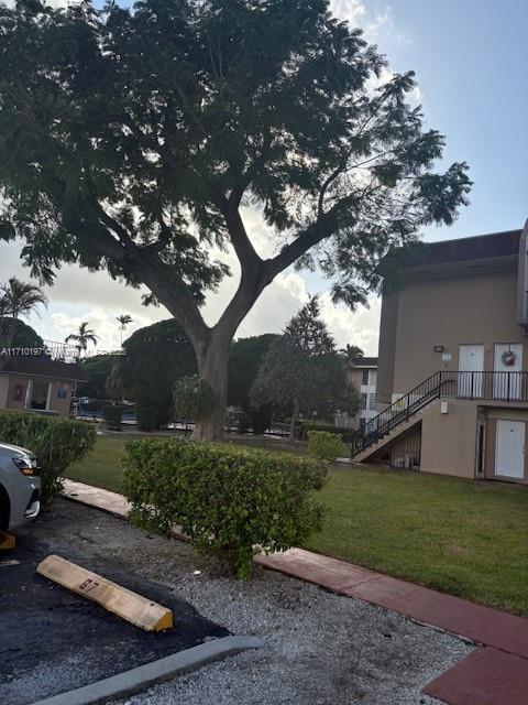 exterior space with uncovered parking, a yard, and stairway